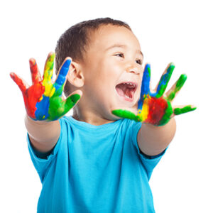 Happy child with painted hands smiling at the camera.